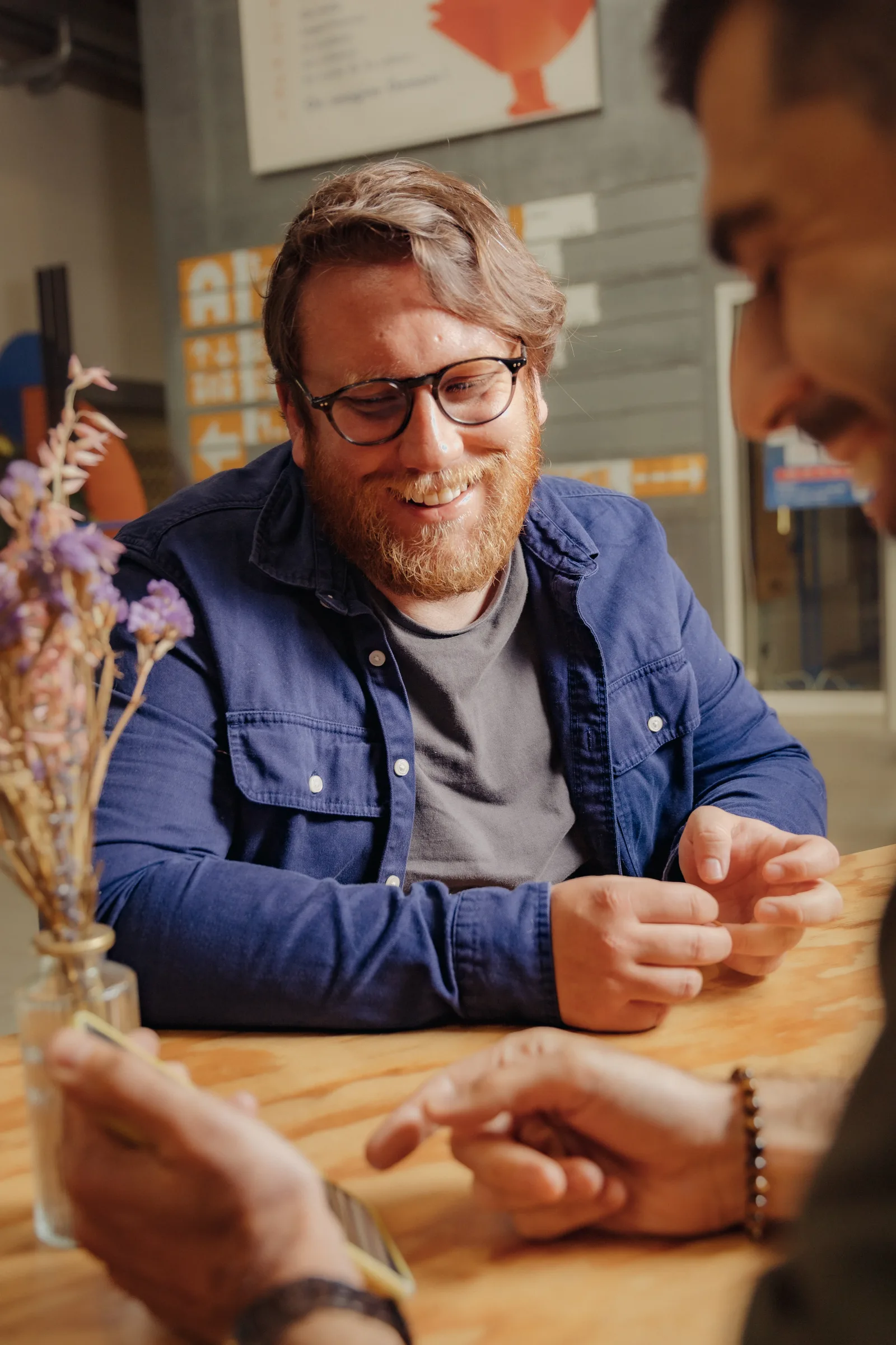 Associé de Lonestone souriant, en pleine discussion autour d'une table en bois